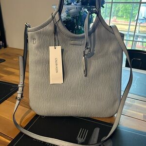 Blue Calvin Klein Satchel bag with handles and shoulder strap.